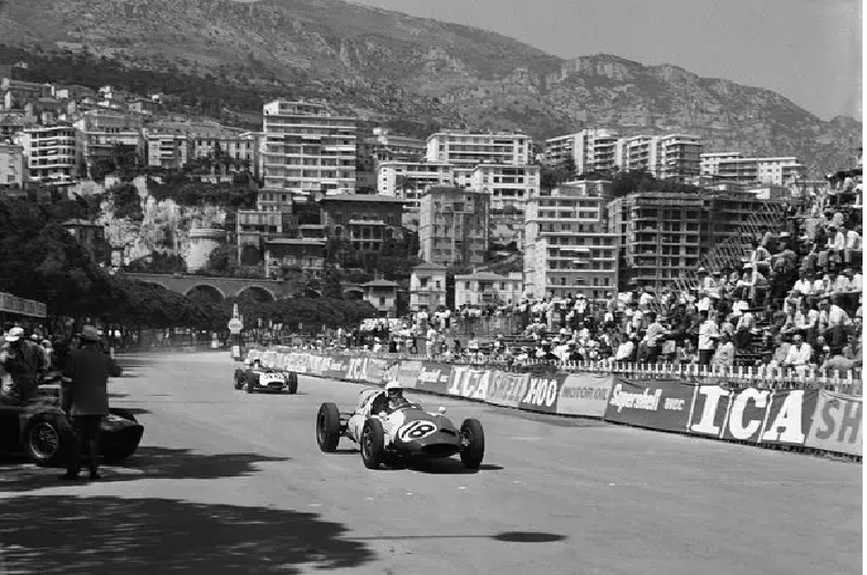 A collection of vintage F1 cars racing on the streets of Monaco.
